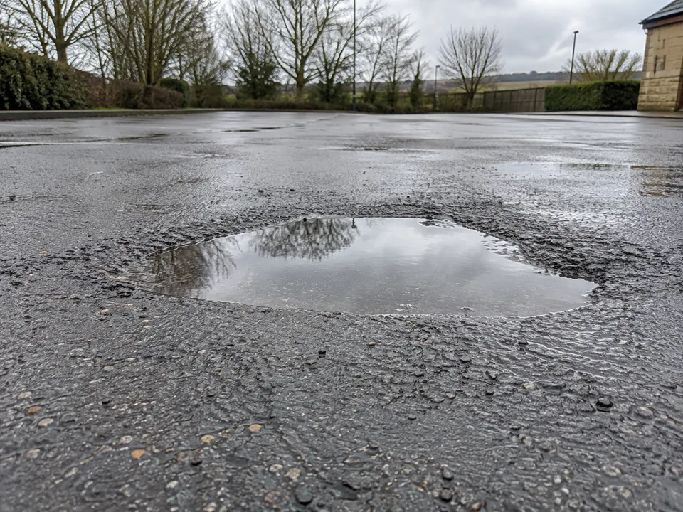 Illustrative example of standing water in a depressed asphalt surface
