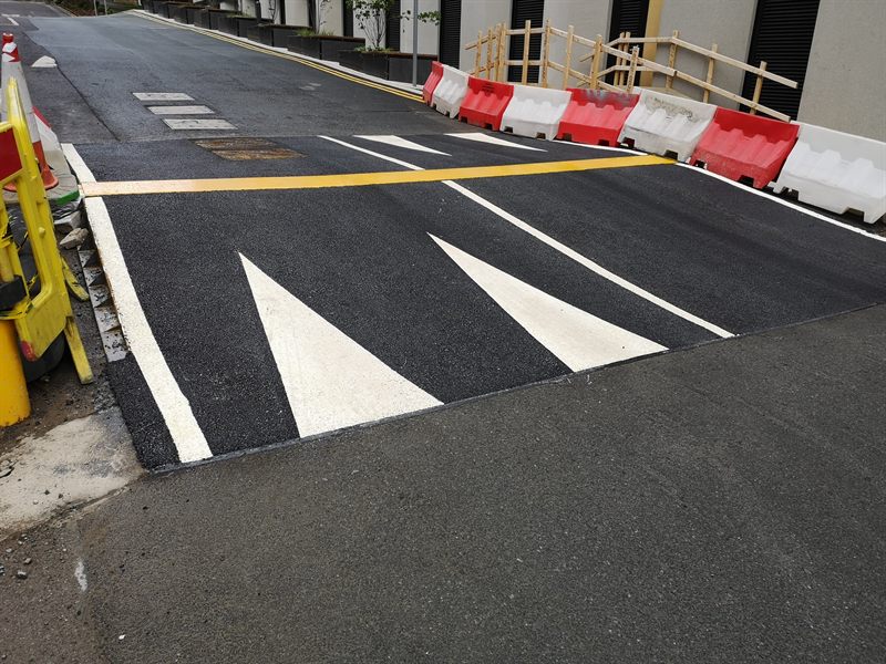 Fresh white directional markings on completed asphalt