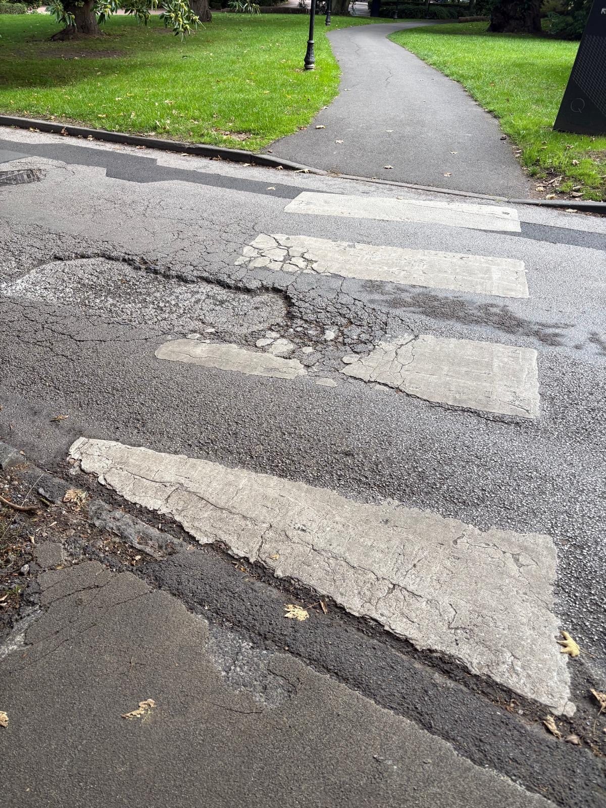 Failed and broken asphalt across the access route at Oulton Hall before repair