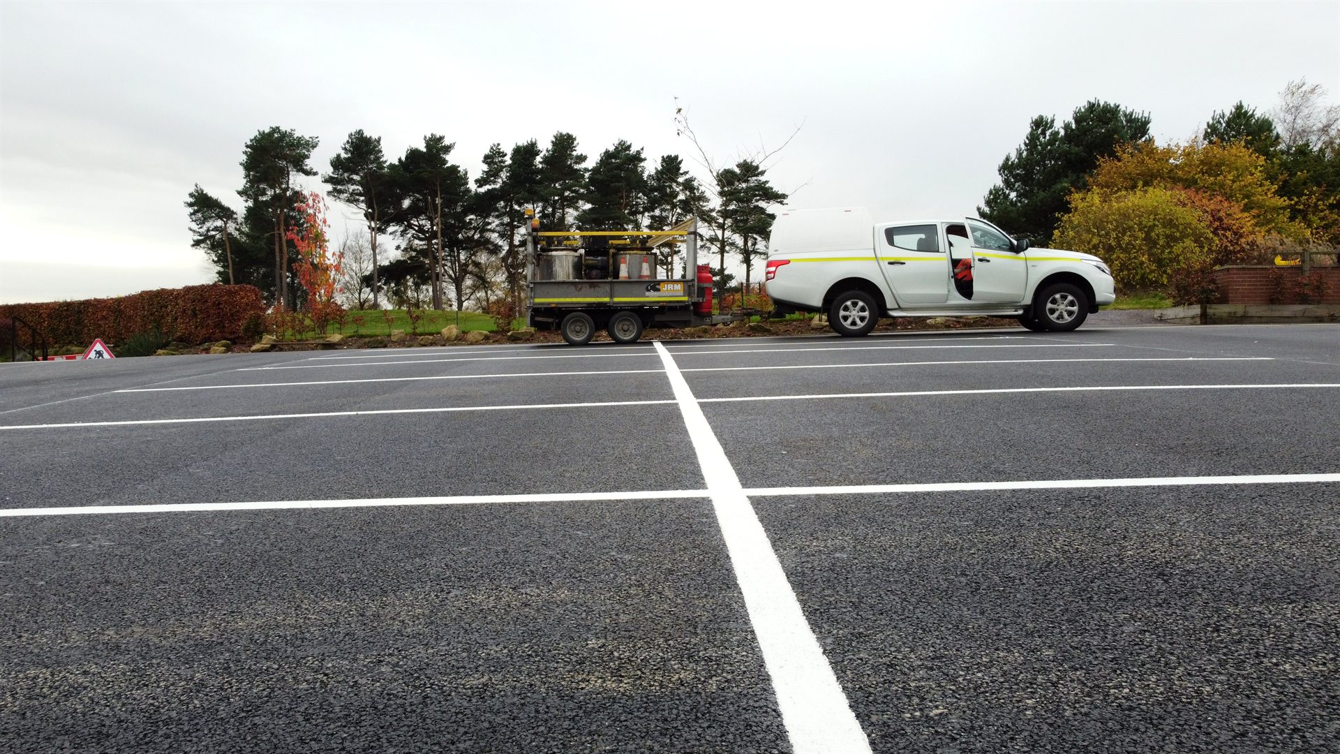 Close aerial view of new asphalt and crisp white parking lines